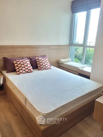 Cozy bedroom with large window and modern wooden furniture