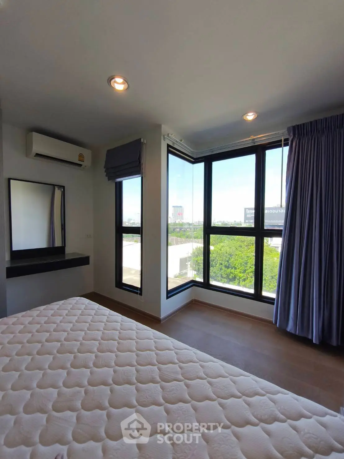 Bright bedroom with large windows offering a stunning view, featuring modern decor and ample natural light.
