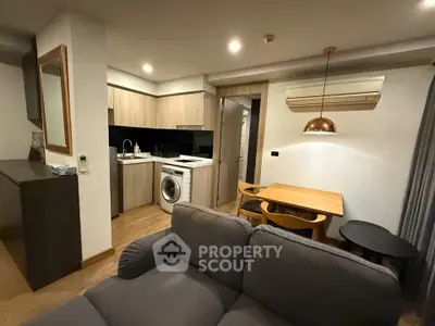 Modern apartment interior with cozy living room and stylish kitchen featuring wooden cabinetry and dining area.
