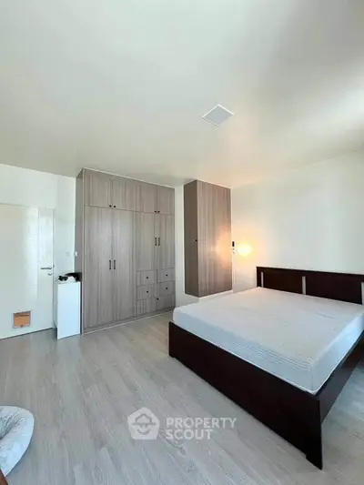 Spacious bedroom with modern wooden furniture and ample storage space