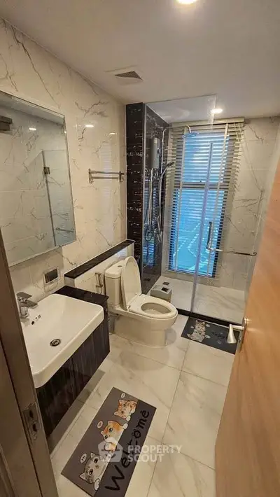 Modern bathroom with elegant marble tiles and glass shower enclosure