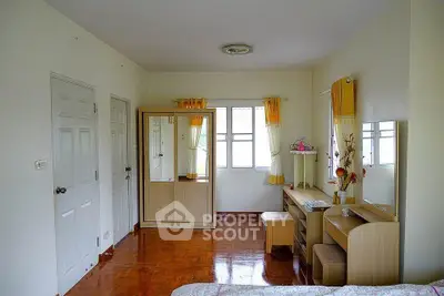 Bright bedroom with wooden flooring, wardrobe, and study desk