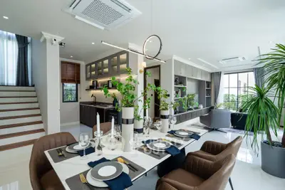 Luxurious open-plan living and dining area with modern decor and greenery