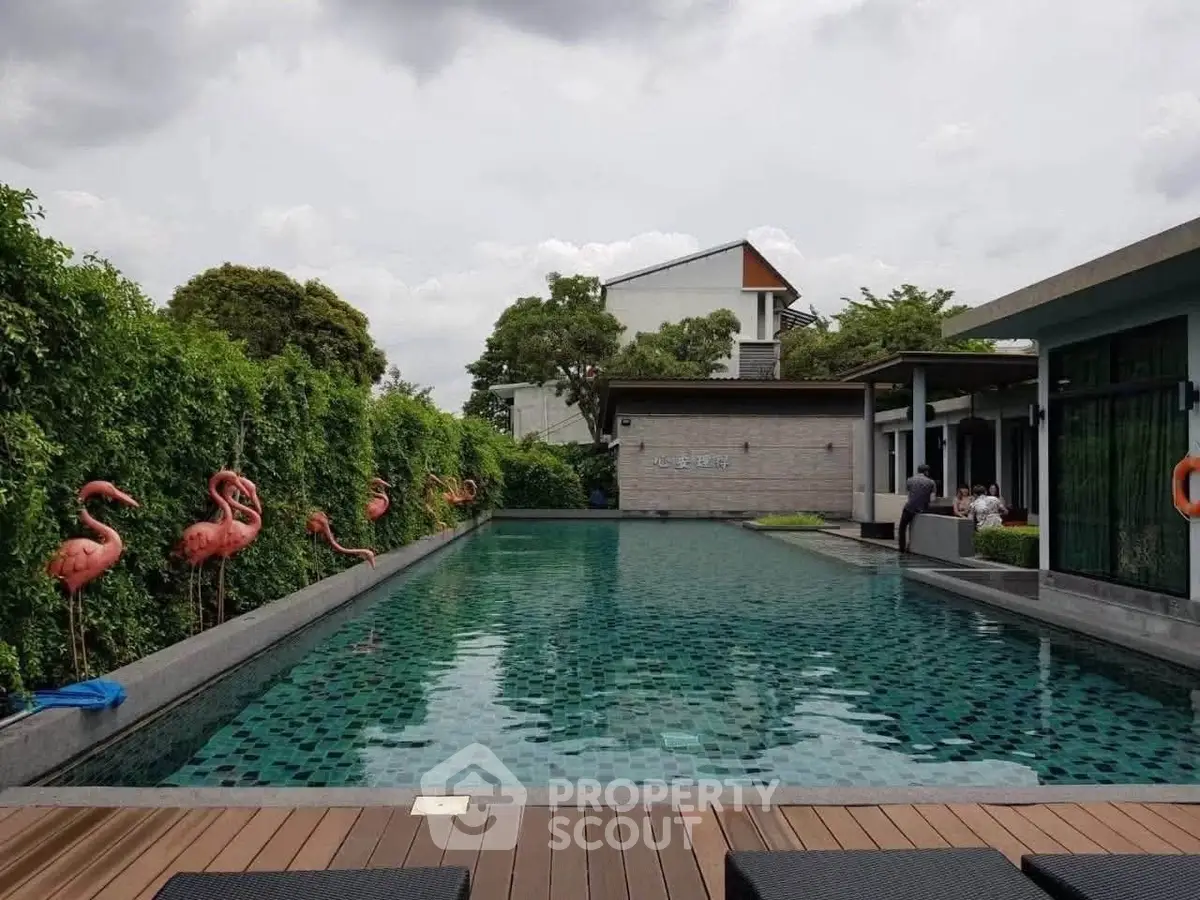 Luxurious outdoor pool area with stylish flamingo decor and lush greenery, perfect for relaxation and leisure.