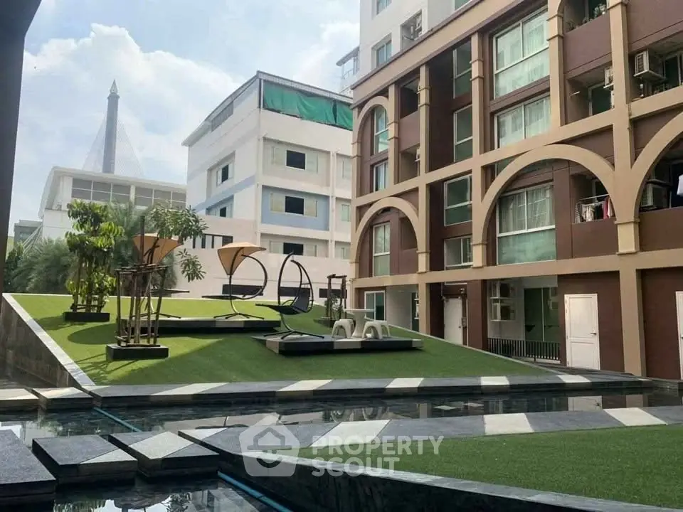 Modern apartment complex with stylish outdoor seating and landscaped garden area.