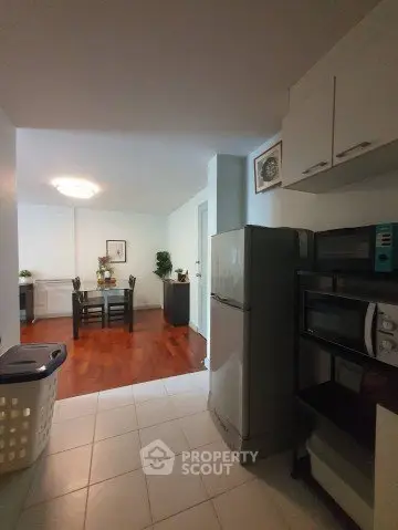 Spacious kitchen with modern appliances and dining area in open layout apartment.