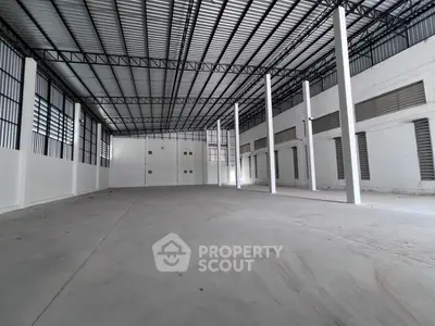 Spacious industrial warehouse with high ceilings and ample natural light, perfect for storage or manufacturing needs.