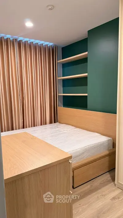 Modern bedroom with stylish green accent wall and built-in shelves