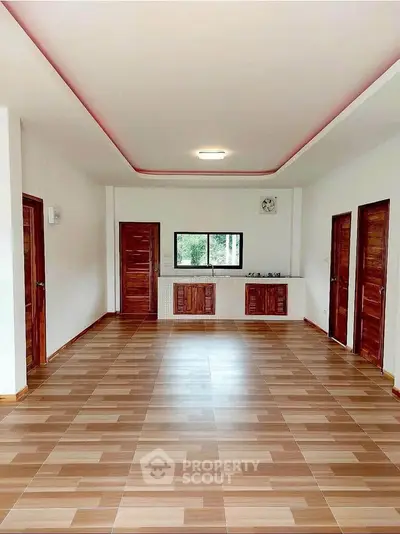 Spacious open-plan living area with modern wooden flooring and ample natural light.