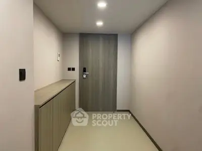 Modern minimalist hallway with sleek wooden door and built-in storage.
