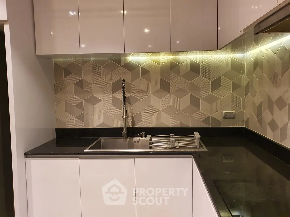 Modern kitchen with sleek cabinetry and geometric backsplash