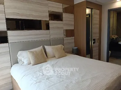 Luxurious bedroom with elegant wood paneling and plush bedding in modern apartment.