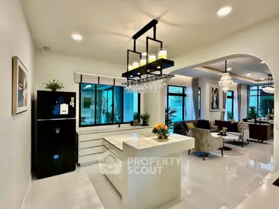 Luxurious open-plan kitchen and living room with modern decor and elegant lighting.
