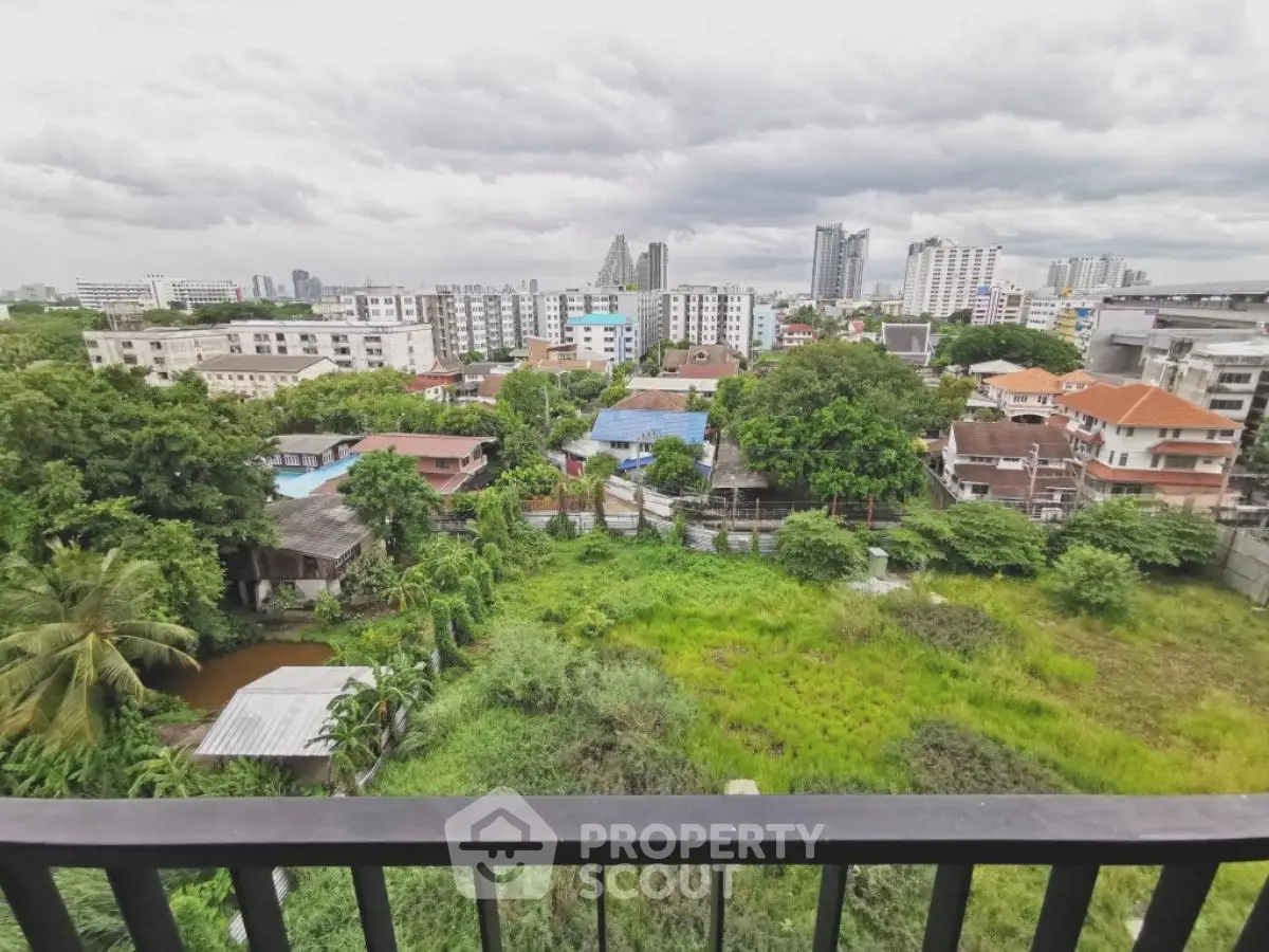 Stunning cityscape view from a high-rise balcony overlooking lush greenery and urban skyline.