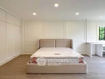 Spacious bedroom with elegant paneling and large bed, perfect for relaxation and comfort.