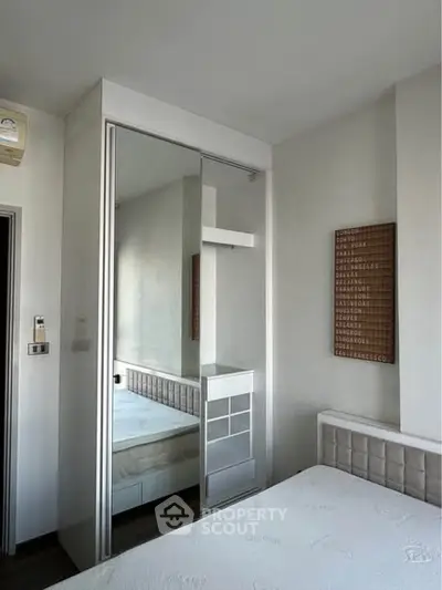 Modern bedroom with sleek mirrored wardrobe and minimalist decor