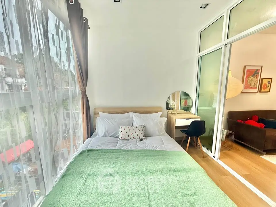Bright bedroom with large windows and modern decor, featuring a cozy bed and stylish furnishings.
