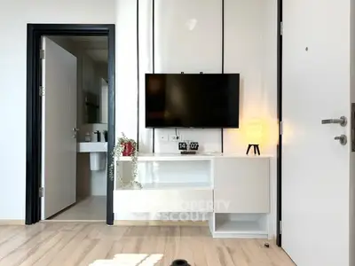 Modern living room with wall-mounted TV and sleek white furniture