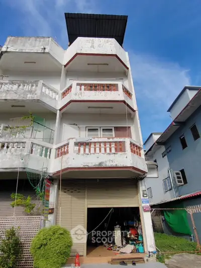 Three-story building with a garage and balconies in urban setting
