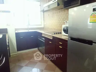 Modern kitchen with sleek cabinets, built-in oven, and spacious fridge in a well-lit space.
