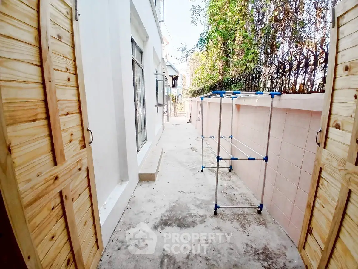 Spacious outdoor area with laundry drying rack and wooden doors