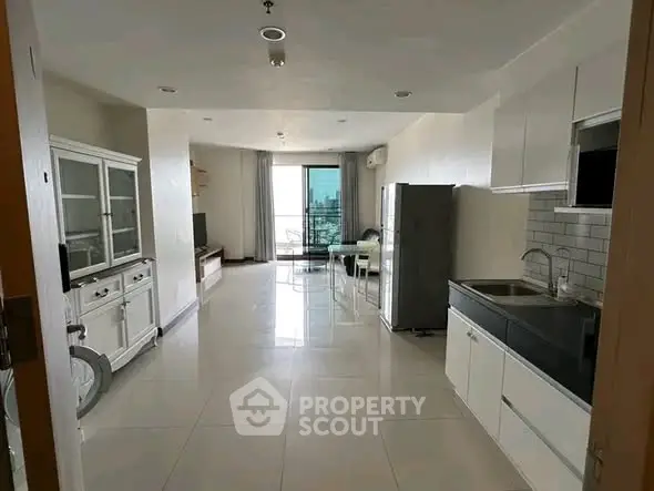 Spacious modern living room with open kitchen and balcony view in a stylish apartment.