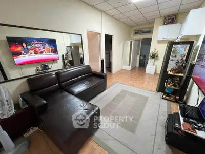Cozy living room with leather sofa and wall-mounted TV in modern apartment