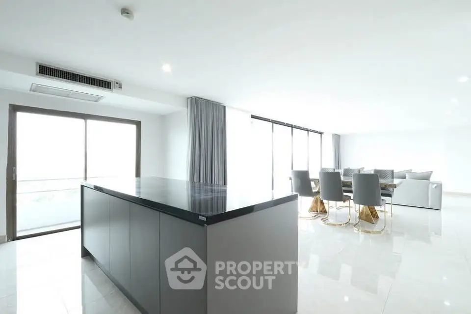Spacious modern living room with open layout and elegant dining area, featuring sleek furniture and abundant natural light.