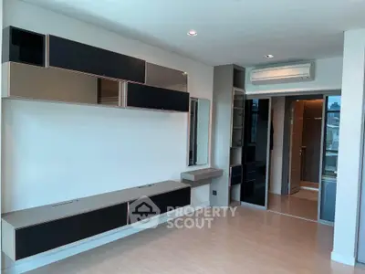 Modern minimalist living room with sleek built-in storage and air conditioning.