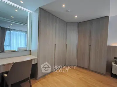 Spacious bedroom with modern corner wardrobe and elegant vanity desk