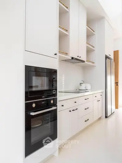 Modern kitchen with sleek white cabinetry and built-in appliances
