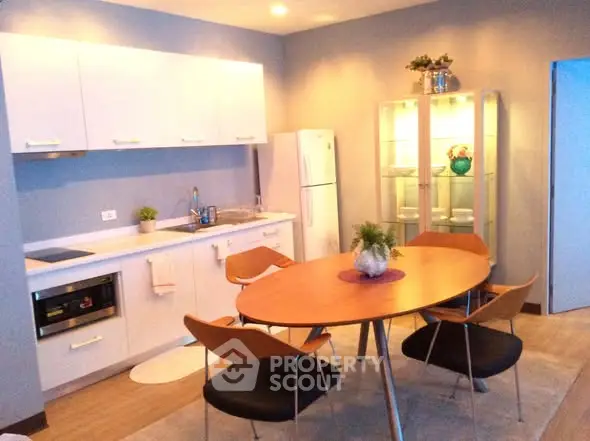 Modern kitchen with sleek design, featuring a dining table and stylish chairs, perfect for contemporary living.