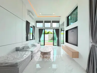 Modern living room with high ceilings, large windows, and sleek furniture in a bright, airy space.