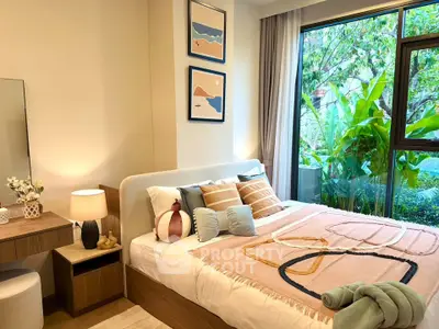 Cozy bedroom with modern decor and large window overlooking lush greenery, perfect for relaxation.