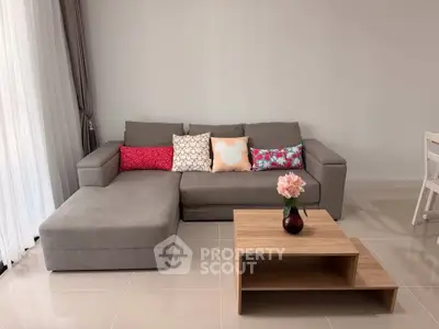 Modern living room with stylish gray sectional sofa and wooden coffee table, perfect for cozy relaxation.
