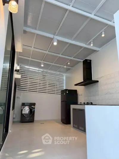 Modern kitchen with gas stove and washing machine in sleek open layout