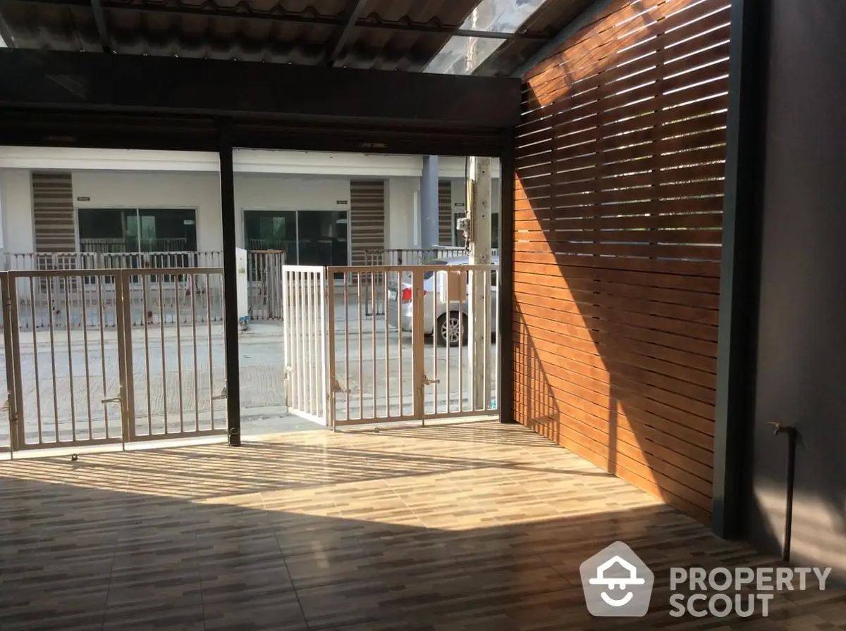 Spacious wooden-floored balcony with modern slatted privacy screens, offering a serene outdoor retreat in a contemporary urban residence.