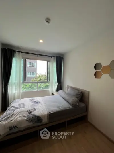 Cozy bedroom with large window and modern decor in urban apartment