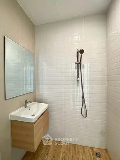 Modern bathroom with sleek shower and stylish vanity in a minimalist design.
