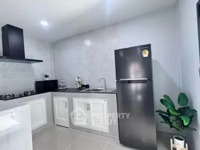 Modern kitchen with sleek appliances and stylish tile backsplash