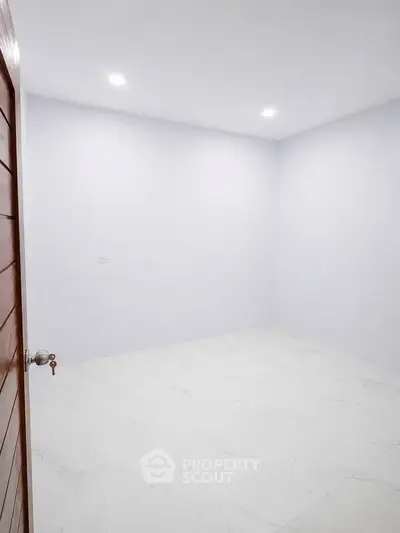 Spacious empty room with white walls and tiled floor, ideal for customization.