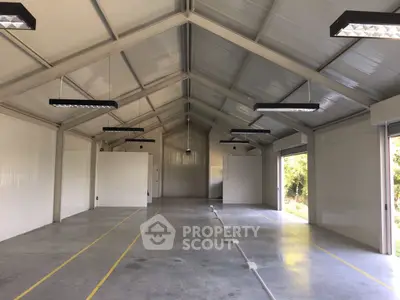 Spacious industrial warehouse with high ceilings and ample natural light.