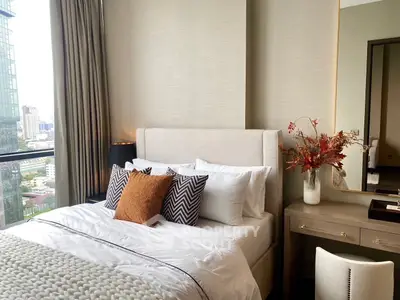 Luxurious bedroom with city view, elegant decor, and stylish furnishings in a high-rise apartment.