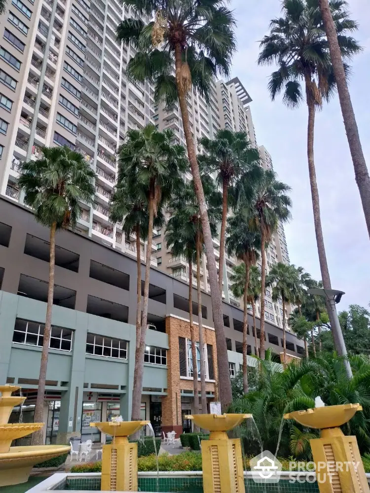 Luxurious high-rise building with palm trees and elegant fountain in urban setting