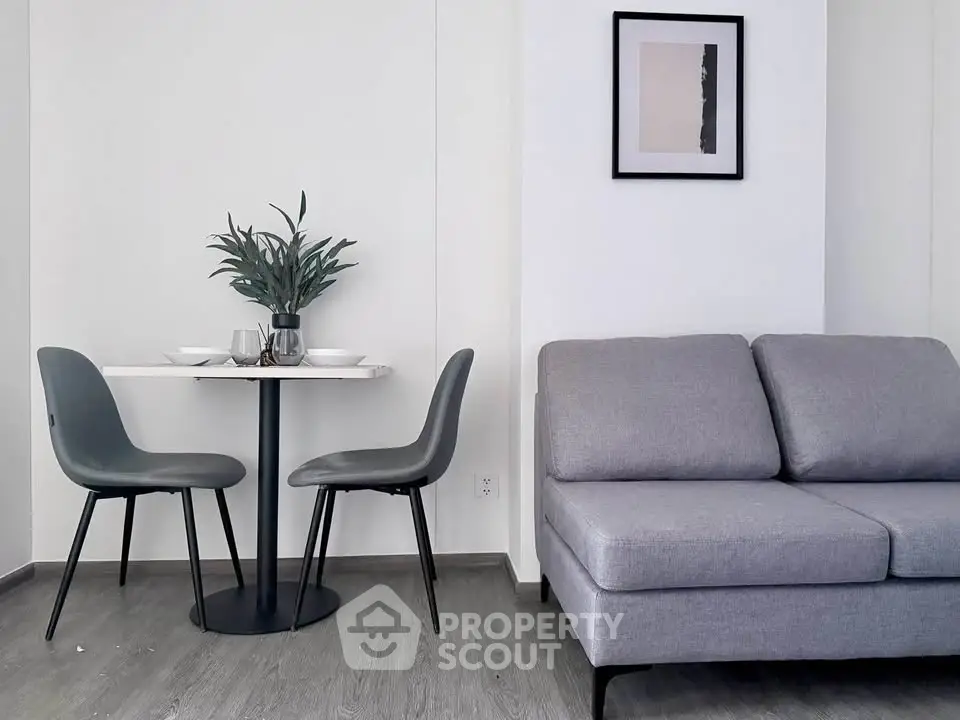 Modern living room with sleek gray sofa and stylish dining set, perfect for contemporary urban living.