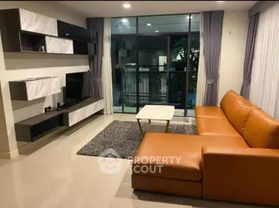Modern living room with sleek furniture and large windows offering a serene view.