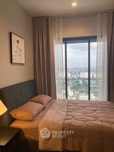 Cozy bedroom with stunning city view from large window, featuring elegant decor and soft lighting.