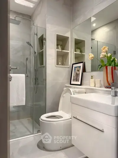 Modern bathroom with sleek design, featuring glass shower and elegant fixtures.