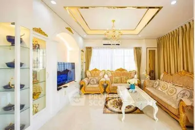 Luxurious living room with elegant gold-accented furniture and chandelier, perfect for sophisticated gatherings.