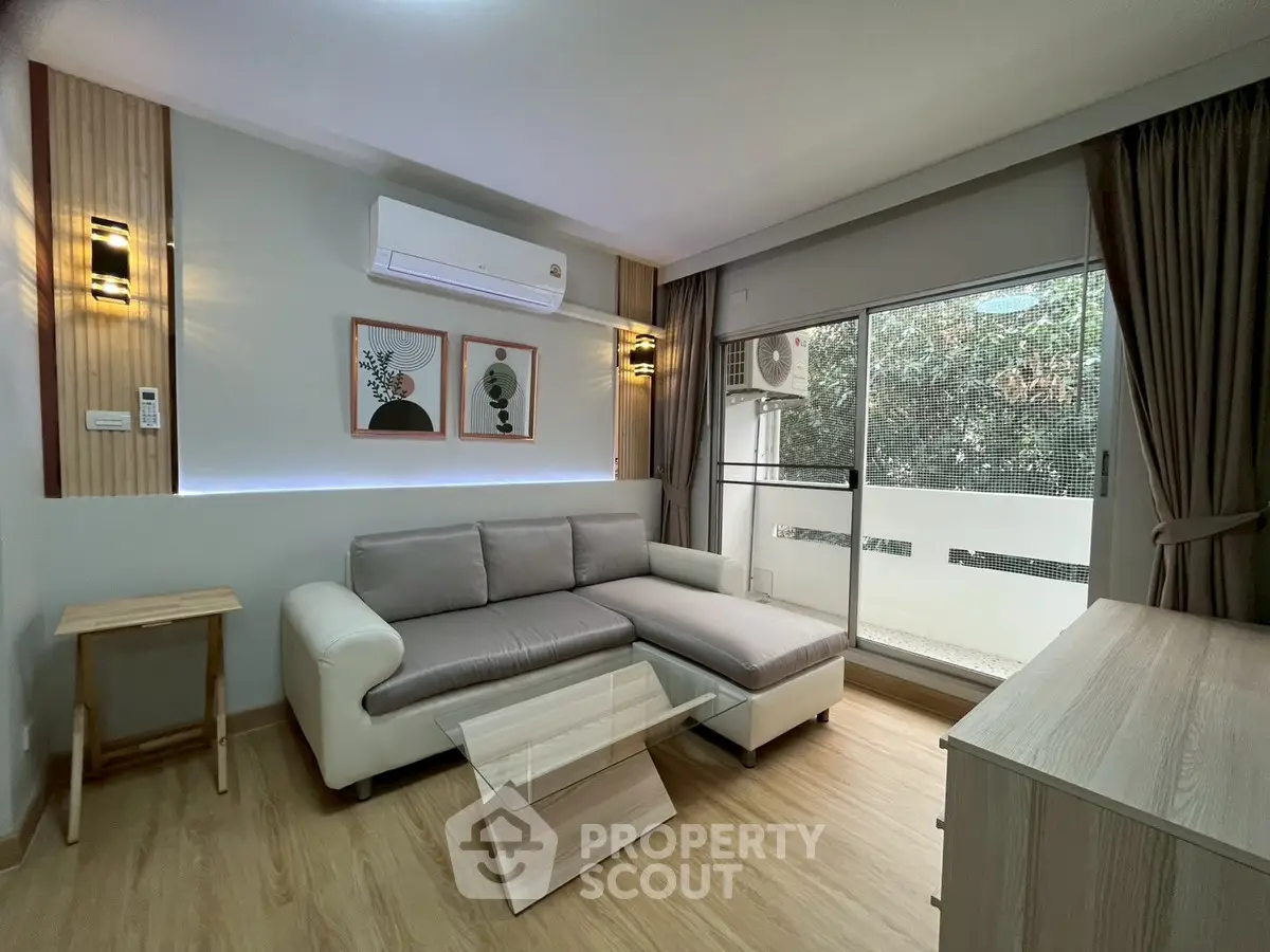 Modern living room with stylish decor and natural light from balcony.